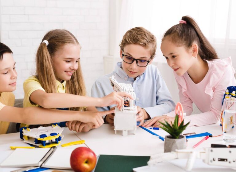 Dwie dziewczynki w czasie zajęć z nauczycielką. Obrazek w artykule: Edukacja włączająca przykłady: jak dostosować nauczanie do potrzeb uczniów?