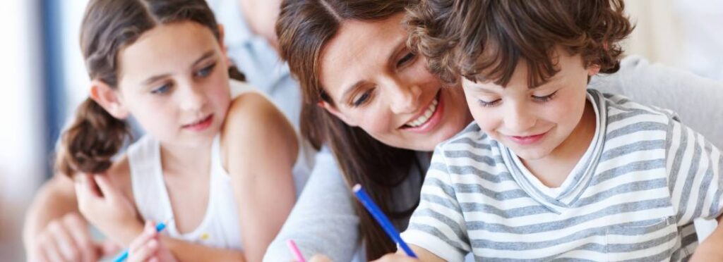 Dzieci podzas zajęć edukacyjnych z nauczycielką. Obrazek w tekście: Edukacja włączająca przykłady: jak dostosować nauczanie do potrzeb uczniów?