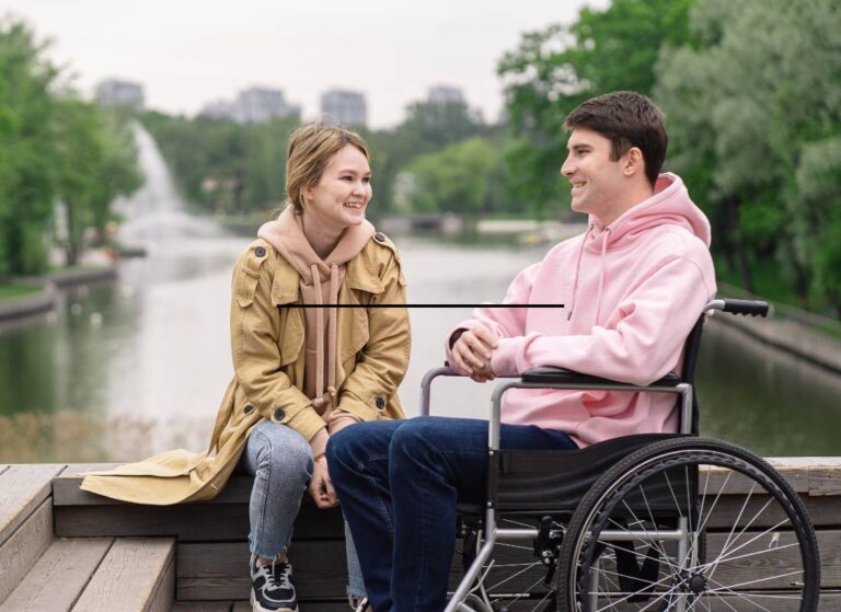 Chłopak na wózku rozmawia z dziewczyną w parku. Obrazek w artykule Portale dla niepełnosprawnych samotnych
