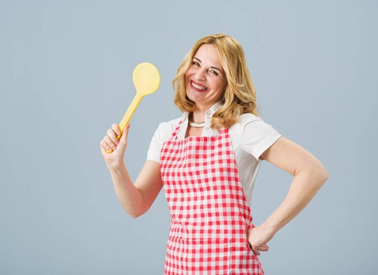 Blondynka w fartuszku z łyżką. Obrazek w artykule Stereotypy przykłady: Co to są i jakie są ich objawy?