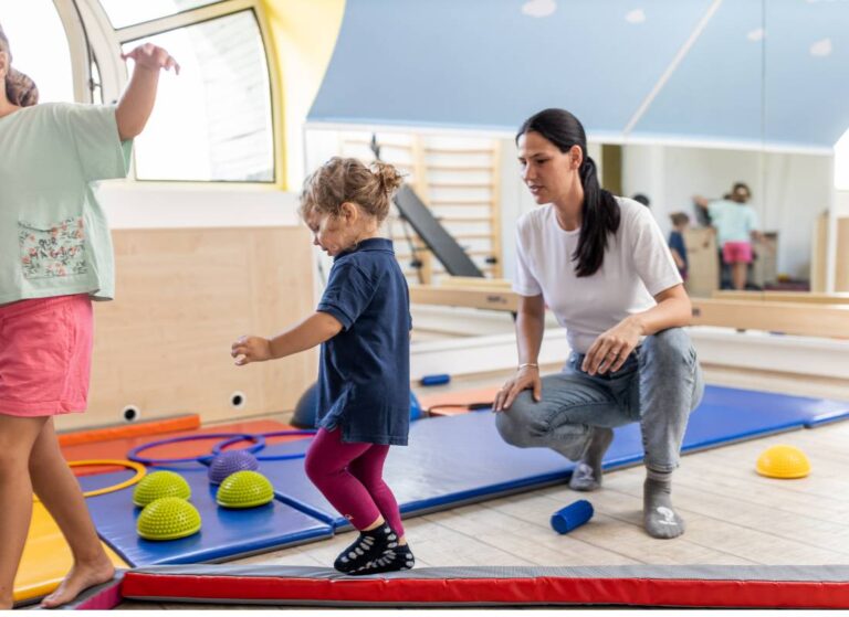 Dziecko z terapeutą podczas ćwiczeń. Obrazek do artykułu Stereotypia u dzieci: przyczyny, objawy i sposoby radzenia sobie